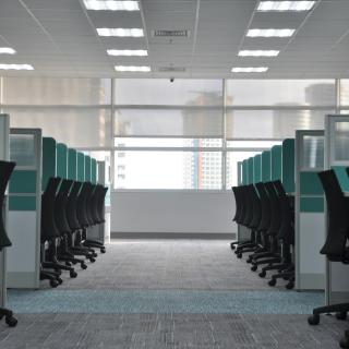 Row of office cubicles with desk chairs