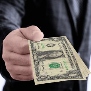 man holding out dollar bill