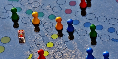 Colorful game pieces dice on a glass surface with interconnected circles.