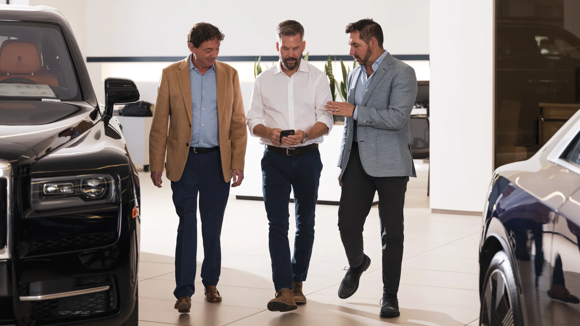three lawyers discussing business at a car dealership
