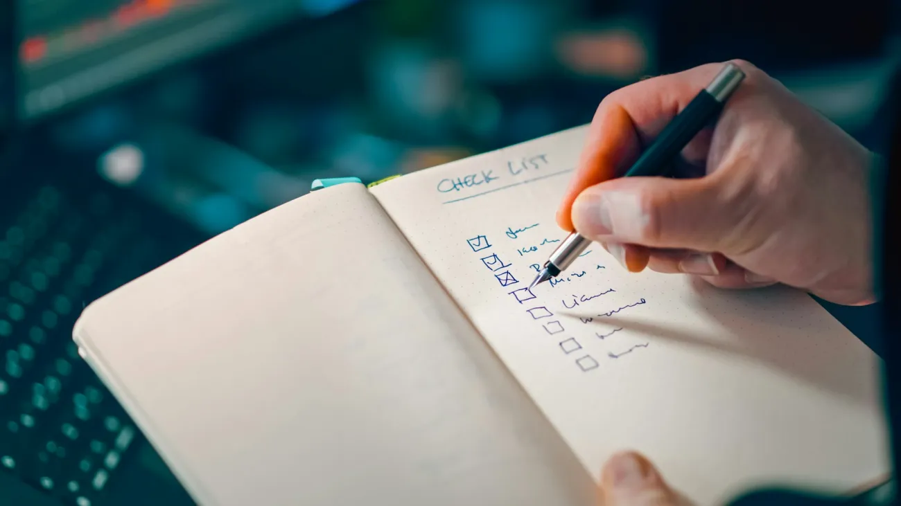 Person checking off items in a hand-written checklist